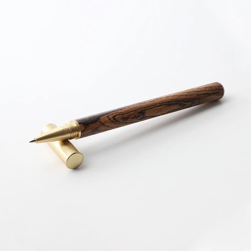 Mordeco wood rollerball pen with black gift box, tiger-stripe wood barrel and brass screw cap on white background