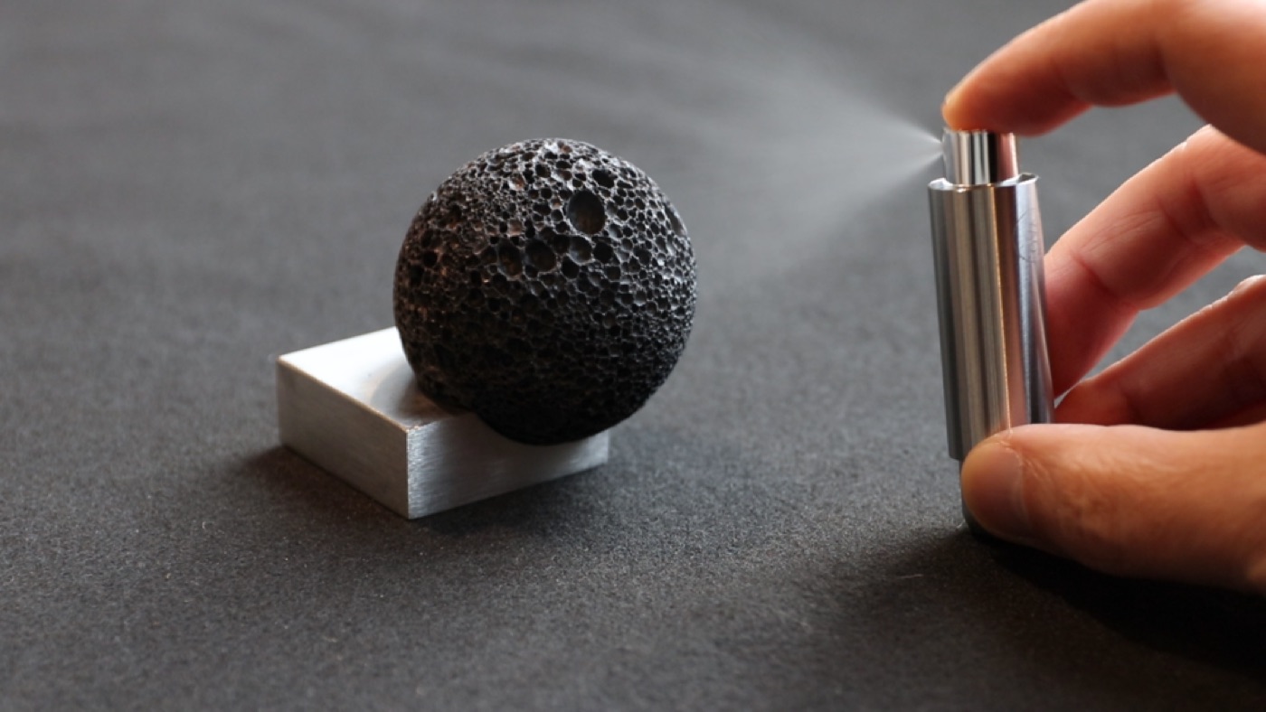 Misting perfume onto the Moon Rock volcanic stone sphere